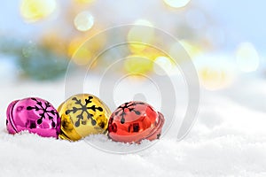 Christmas jingle bells in the snow and defocused lights