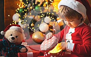 Christmas kid. Happy little smiling boy with christmas gift box. Happy child holding a red gift box with both hands