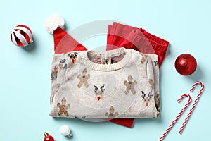 Christmas kids clothes set. Cotton pants, sweater, Christmas hat and decorations on blue background