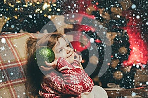 Christmas kids mood. Cute angel of Christmas with shining balls. The child looks up dreamily. Waiting for Christmas