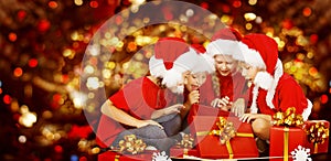 Christmas Kids Opening Present Gift Box, Children in Santa Hat photo