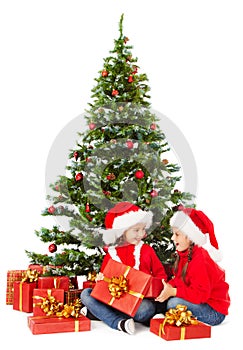 Christmas kids in Santa hat under xmas tree, open present gift box