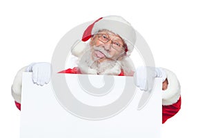 Christmas. Kind Santa Claus in white gloves with his tongue sticking out holds an empty white cardboard and shows faces