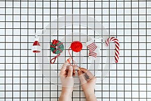 Christmas Knit Toys. Handmade DIY Crochet hat, lollipop, donut and sock and female hand with crochet hook on checkered