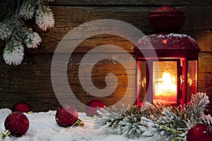 Christmas lantern with baubles on snow