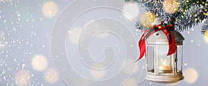 Christmas lantern with candle hanging on snowy fir tree branch against light background, space for text. Banner design