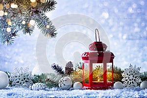 Christmas lantern in snow with fir tree branch and holiday decorations. Winter cozy scene