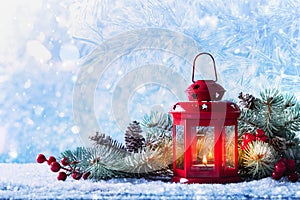 Christmas lantern in snow with fir tree branch. Winter cozy scene photo