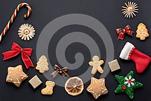 Christmas layout on a black background, New Year symbols: gingerbread cookies, bows, decorations for the New Year tree.