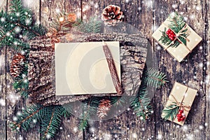 Christmas letter on wooden background with Christmas gifts, bark texture, pencil, Fir branches, pine cones