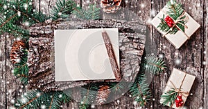 Christmas letter on wooden background with Christmas gifts, bark texture, pencil, Fir branches, pine cones, red decorations.