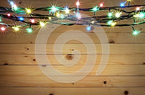 Christmas light boarder on wooden background.