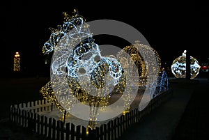 Christmas: Light shooting: festive glowing street decoration. Light sculpture,figure of Cinderella\'s carriage and horse