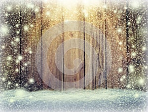 Glow of festive lights and a wooden background in the snow. Chr