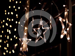 Christmas lighting decoration with bright LED lights in the shape of a gold star sparkles glitter.