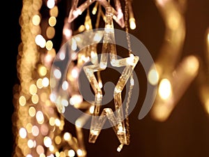 Christmas lighting decoration with bright led lights in the shape of a gold star sparkles glitter.