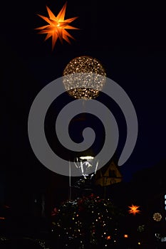 Christmas lights above a streep lamp in front of a church photo