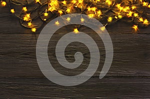 Christmas lights border on grey wooden background