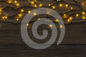 Christmas lights border on grey wooden background