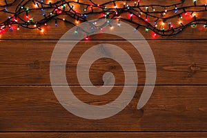 Christmas lights border on wood background