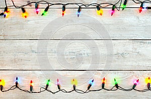 Christmas lights bulb frame decoration on white wood.