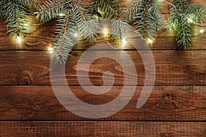 Christmas lights bulb and pine tree branches decoration on vintage wooden table. Merry Christmas and New Year holiday background.