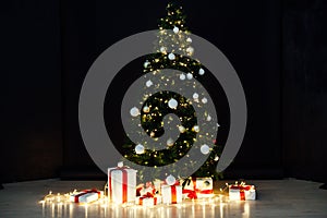 Christmas lights with Christmas tree and gifts on a black background