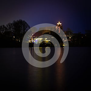 Christmas lights of a church reflected in a lake  in the dark