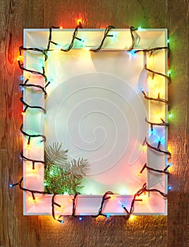 Christmas lights frame on wooden background