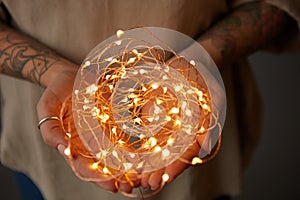 Christmas lights garland in female hands