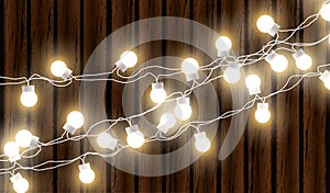 Christmas lights isolated on dark wooden background. Glow garland. Vector glow xmas light bulbs on wires.