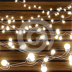 Christmas lights isolated on dark wooden background. Glow garland. Vector glow xmas light bulbs on wires.