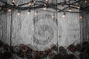 Christmas Lights and Pine cones on Rustic Wood