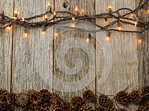 Christmas Lights and Pine cones on Rustic Wood