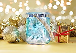 Christmas lights in rustic blue jar against bokeh lights background