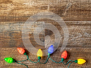 Christmas lights on rustic wood background.