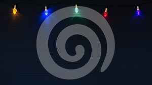 Christmas Lights on String Glowing against a Dark Navy Blue Wood Board Background with Copy Space below with a horizontal crop