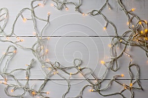 Christmas lights on white wooden background.