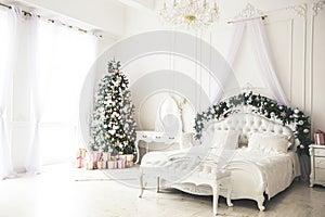 Christmas living room with a Christmas, gifts tree and bed. Beautiful New Year decorated classic home interior. Winter background