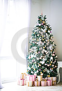 Christmas living room with a Christmas tree, gifts and a large window. Beautiful New Year decorated classic home interior