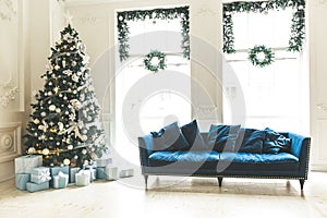 Christmas living room with a Christmas tree, sofa, gifts and a large window. Beautiful New Year decorated classic home interior