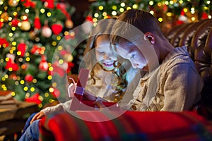 Christmas magic gift box a children. on the couch in a cozy dark