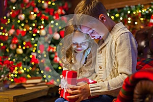 Christmas magic gift box a children. on the couch in a cozy dark