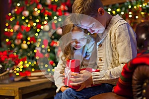 Christmas magic gift box a children. on the couch in a cozy dark