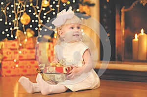 Christmas, magic, people concept - happy baby with gift