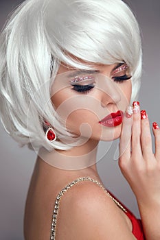 Christmas makeup. Red lips Makeup. Beautiful blond closeup portrait. Manicured nails. Jewelry. White Short bob hairstyle. Sensual