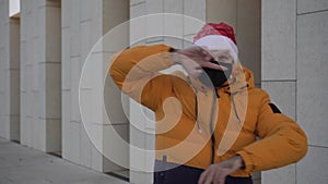 Christmas, a man in a protective medical mask is dancing in a Santa Claus hat