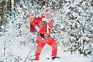 Christmas man in snow. Happy new year. Santa Claus pulling huge bag of gifts on white nature background. Santa in the