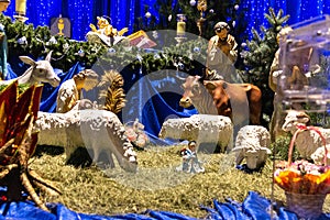 Christmas manger with figurines of Jesus, Mary, Joseph, sheep, bull, donkey and magi.