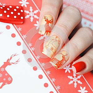 Christmas manicure with deers on the background of the gift box